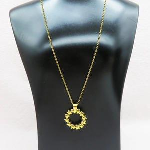 Detailed view of a golden pentagram ring pendant displayed on a black neck mannequin