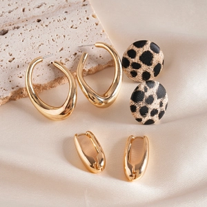 Detailed set of 3 earring pairs with leopard print and golden waterdrop designs on silk