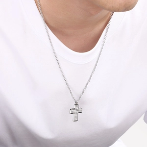 Minimalist stainless steel cross pendant necklace with cubic zirconia on a white t-shirt