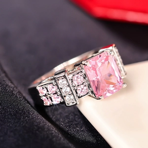 Macro shot of square pink gemstone ring with silver band and micro-inlaid diamonds