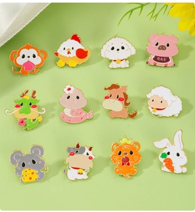 Flat lay of 12 cute zodiac animal enamel pins on a soft light green background