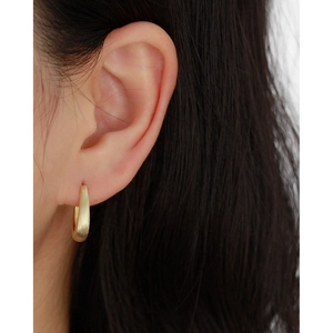 Close-up of golden matte finish hoop earring worn on model for a premium minimalist style