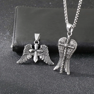 Detail shot of punk angel wing cross pendant with zircon inlay on black leather background