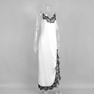 Détail de la dentelle noire délicate sur une robe en satin blanc fendu
