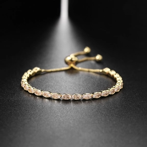 Adjustable gold tennis bracelet with marquise-cut champagne zircon stones on black background