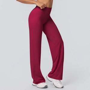 Detail of high waisted flared yoga pants in wine red showing fabric drape and fit