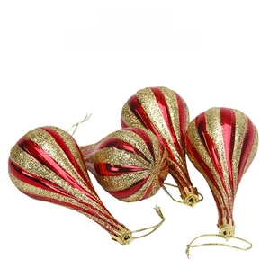 Close-up of four red and gold glitter teardrop Christmas ornaments with hanging strings