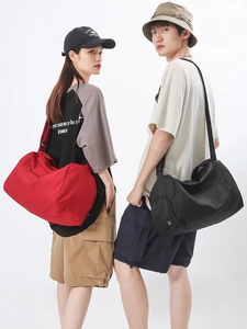 Sac de voyage sport de grande capacité noir et rouge porté par des modèles homme et femme