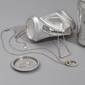 Close-up of dual-tone soda tab pendants on silver chains with 925 hallmark engraving