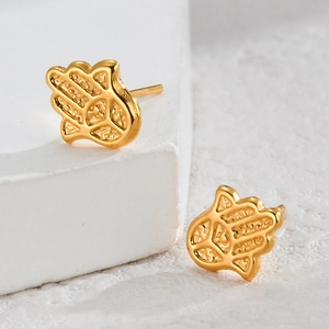 Minimalist gold Hamsa Hand stud earrings in matte finish on white stone background