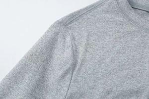 Macro shot of grey knitted T-shirt showing detailed neckline and double-needle stitching