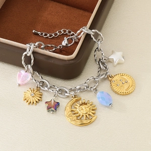Detailansicht von Sonnen- und Mondanhängern an Silberarmband über Schmuckkästchen