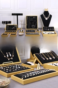 Detailed view of black velvet jewelry display trays with elegant gold metal frames