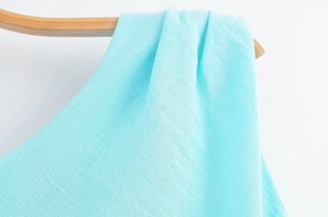 Détail de la texture en lin bleu clair sur le tissu d'une robe midi asymétrique