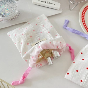 Close-up of heart print cotton drawstring bag storage with pink heart patterns and label