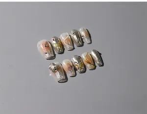 Detail of 3D nail art stickers with silver mirror finish, gold bows and luxury rhinestones