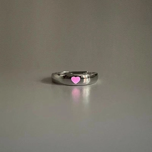 Detail of silver adjustable open ring featuring a glowing pink heart-shaped center