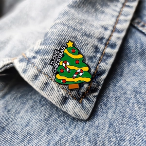 Cute green enamel Christmas tree brooch with I LOVE CHRISTMAS text on denim background
