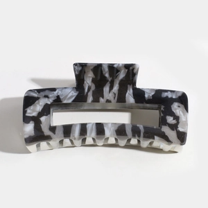 Detailed macro view of rectangular hair claw clip with black and white marble pattern texture