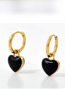 Detail of heart-shaped stainless steel drop earrings in gold with black enamel finish