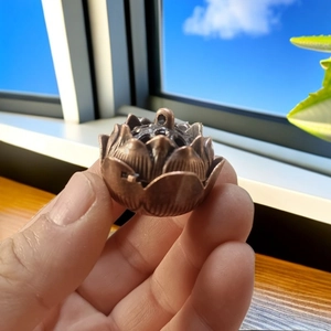 Close-up of a vintage bronze lotus censer with intricate multi-layer petals in hand