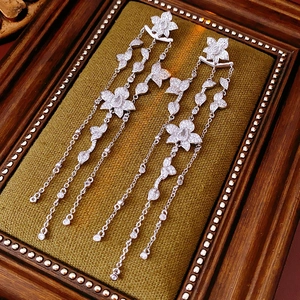 Detailed view of silver petal earrings with long zircon tassels in a vintage frame