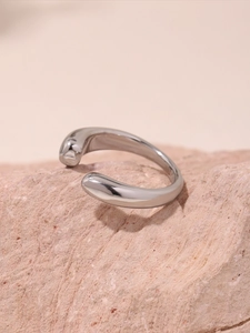 Minimalist silver open ring on textured pink stone highlighting sleek metallic finish