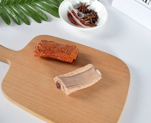 Detailaufnahme realistischer PVC-Fleischmodelle mit Fasern auf einem Holzbrett