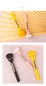 Detailed view of large fluffy makeup powder brushes with golden ferrules in three colors