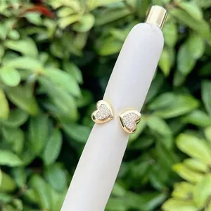 Macro detail of gold-plated heart earrings with white cubic zirconia pavé setting