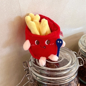 Close-up of plush french fries doll with cute embroidery on a glass jar lid