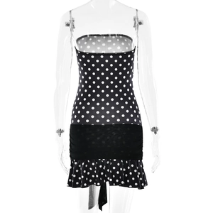 Detailed view of polka dot tube dress featuring black waist band and ruffled hemline