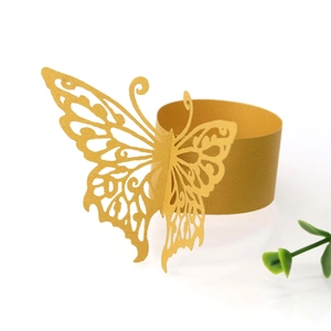 Detail of laser-cut golden butterfly paper napkin ring with intricate hollow wings