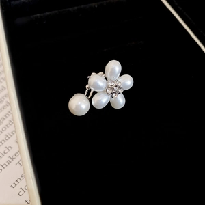 Vue macro de clip d'oreille fleur en perles et zircons sur velours noir élégant