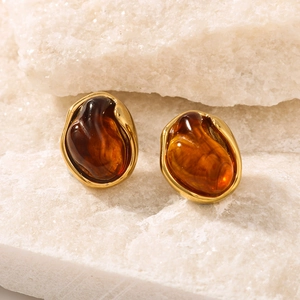 Inlaid resin stud earrings in 18K gold plated stainless steel on a stone background