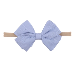 Detailed view of lavender purple bow headband with textured fabric on soft nylon band