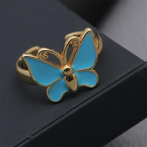 Macro shot of an adjustable blue butterfly ring resting on a black textured jewelry box