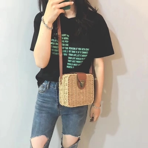 Detail of hand-woven straw crossbody bag with brown leather flap and retro metal buckle