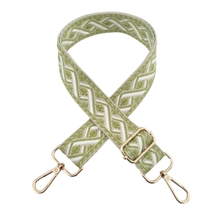 Detail of adjustable green and white jacquard bag strap with gold metal lobster clasps