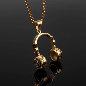 Macro detail of a polished gold headphone pendant featuring intricate mesh on the earcups