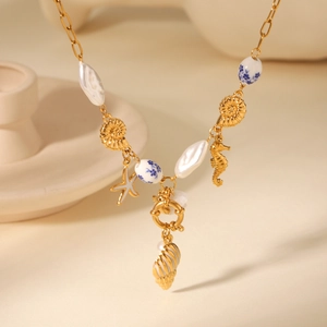 Detailed close-up of ocean-themed necklace with golden seahorse, starfish and pearl charms