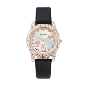 Gros plan d'une montre en or rose avec strass et bracelet en cuir noir texturé