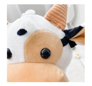 Close-up of cute cow plush bag with soft texture and detailed cartoon animal features