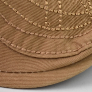 Vue macro des coutures décoratives précises sur une casquette en coton marron rétro