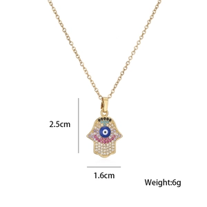 Detail view of gold Hamsa pendant with colorful stones, measuring 2.5cm by 1.6cm