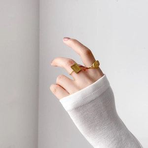 Chic gold-plated sun and moon signet rings with radial texture on a female hand