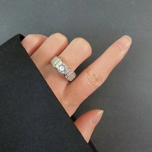 Close-up of a men's silver classic moissanite ring with a brilliant round center stone