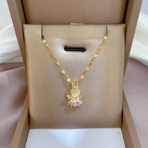 Golden cat eye angel necklace with zircon details in a brown jewelry box on silk