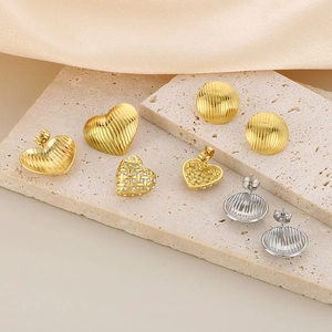 Makroaufnahme von 18K Gold und Silber Herz und runden Ohrringen auf Steinsockel