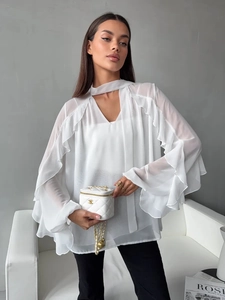 Detail of white chiffon blouse with bell sleeves, layered ruffles and halter V-neck design